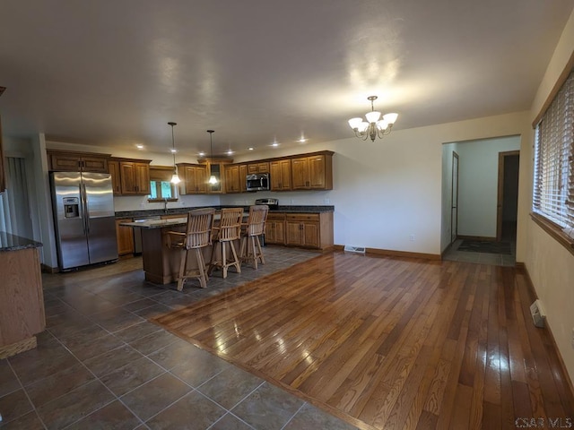 350 American Legion Rd, Latrobe, PA 15650 - kitchen with appliances with stainless steel finishes, a chandelier, a center island, a breakfast bar area, and brown cabinets