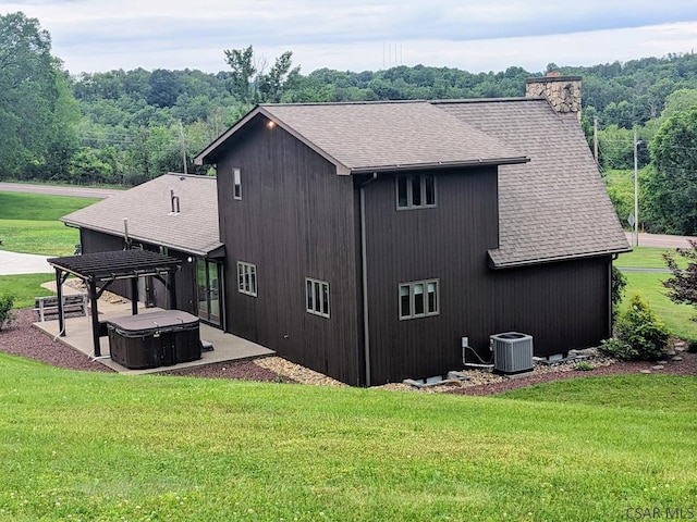 350 American Legion Rd, Latrobe, PA 15650 - back of property featuring a hot tub, a shingled roof, a patio area, a yard, and a chimney