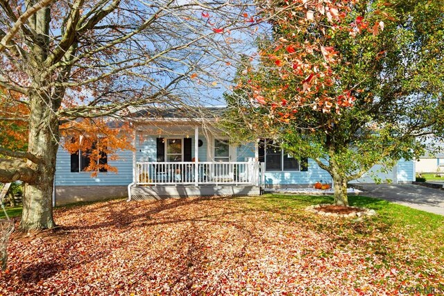 view of property hidden behind natural elements with covered porch