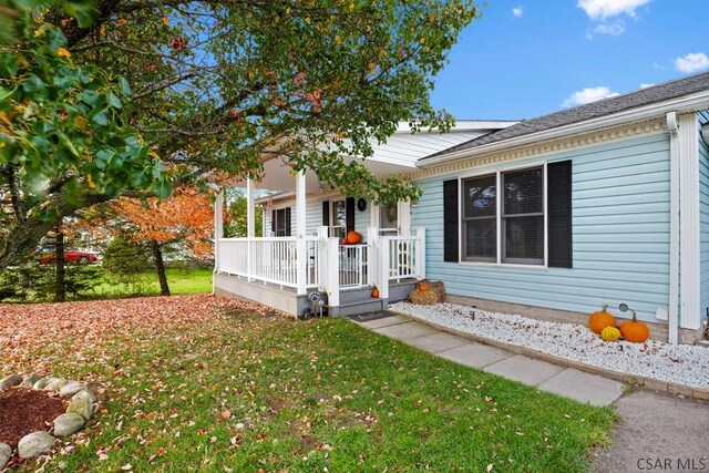 view of front of house with a porch and a front lawn