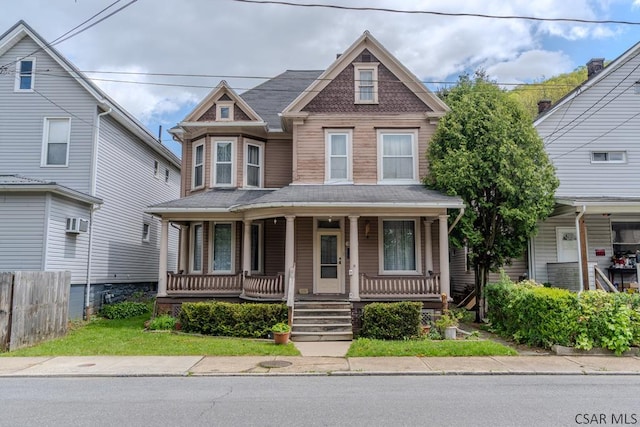 victorian-style house with a porch and fence