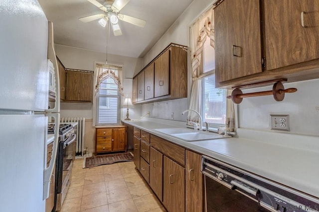 kitchen with a sink, freestanding refrigerator, stainless steel gas stove, dishwasher, and light countertops