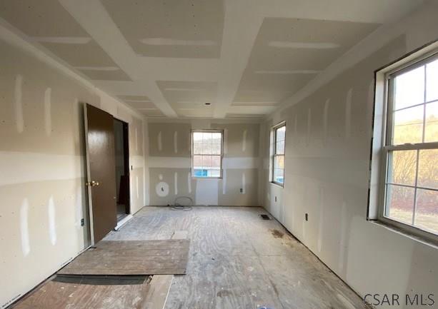 unfurnished room featuring coffered ceiling