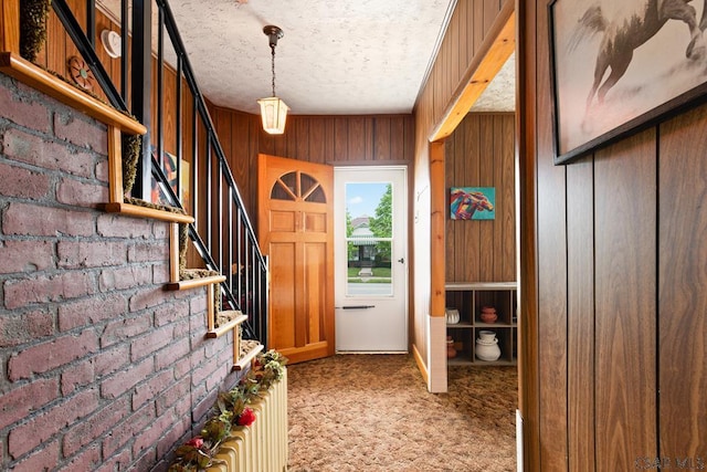 540 S Center Ave, Somerset, PA 15501 - doorway to outside with light colored carpet, stairway, a textured ceiling, wooden walls, and brick wall