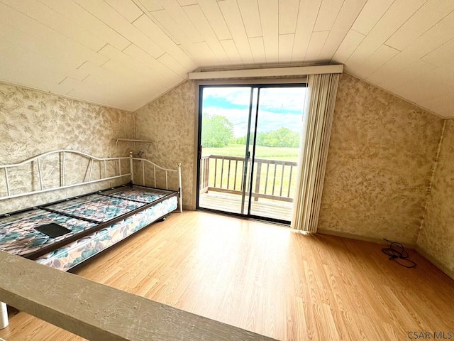 152 Aviator Ln, Friedens, PA 15541 - unfurnished bedroom featuring wood finished floors, wallpapered walls, vaulted ceiling, and access to outside