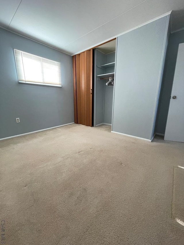 unfurnished bedroom with light carpet and a closet