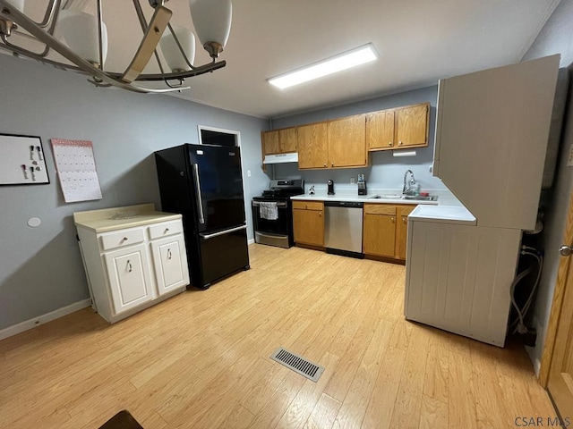 kitchen with stainless steel appliances, sink, and light hardwood / wood-style flooring