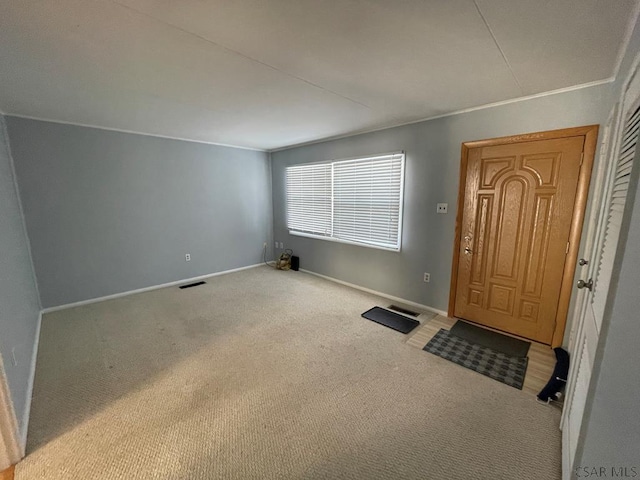 foyer entrance featuring carpet flooring