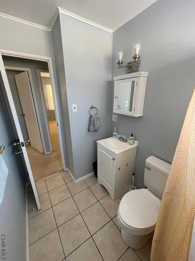 bathroom with tile patterned flooring, vanity, ornamental molding, and toilet