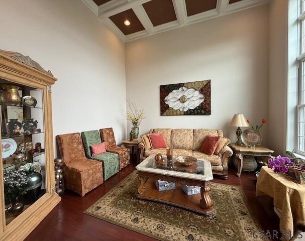 living area with crown molding, coffered ceiling, wood finished floors, and beamed ceiling