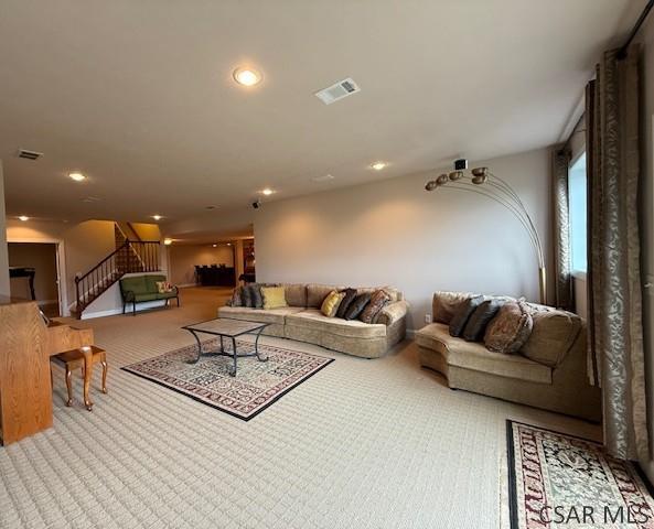 carpeted living room with stairs and recessed lighting