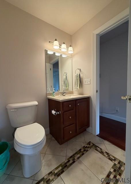 bathroom with vanity, tile patterned floors, toilet, and baseboards
