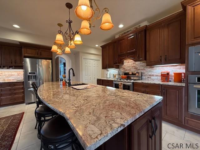 kitchen featuring appliances with stainless steel finishes, a sink, light tile patterned flooring, recessed lighting, and tasteful backsplash