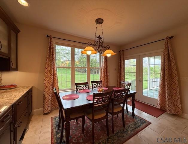 dining room featuring healthy amount of natural light, baseboards, and light tile patterned floors