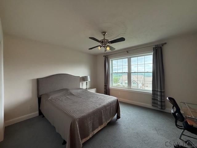 bedroom featuring baseboards, a ceiling fan, and carpet