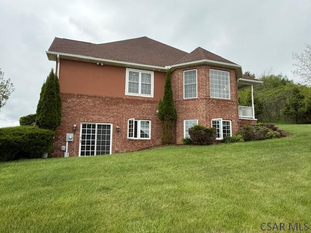 rear view of house with a yard and brick siding