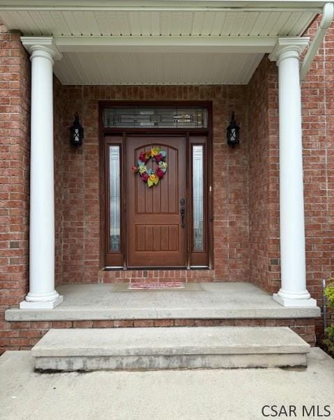 view of exterior entry featuring brick siding