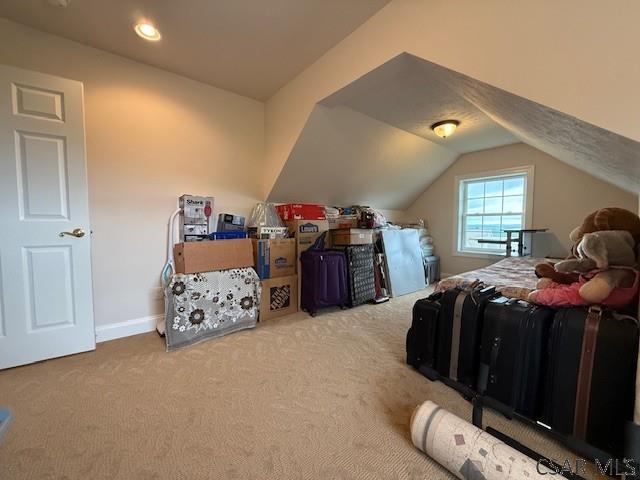 bedroom featuring carpet flooring, lofted ceiling, and baseboards