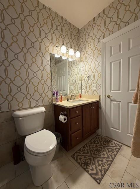 bathroom featuring wallpapered walls, vanity, toilet, and tile patterned floors
