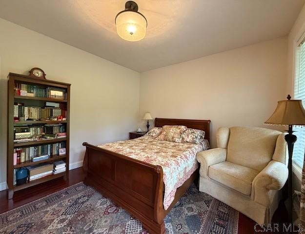 bedroom featuring wood finished floors and baseboards