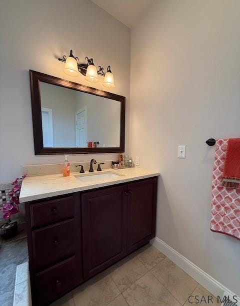 bathroom featuring tile patterned floors, vanity, baseboards, and lofted ceiling
