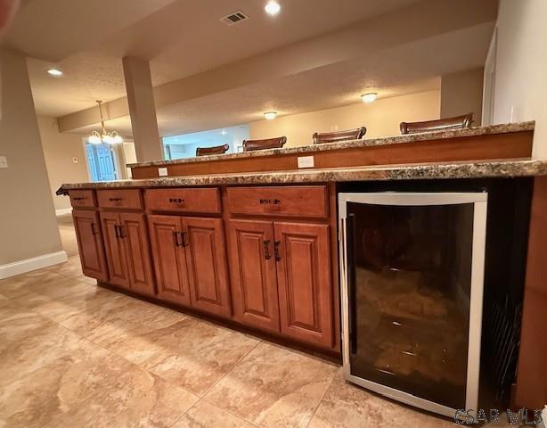bar area featuring baseboards, wine cooler, and recessed lighting