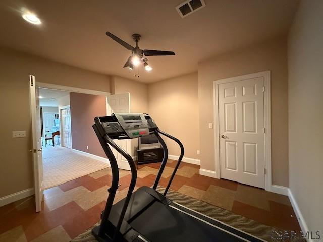 workout room with a ceiling fan and baseboards