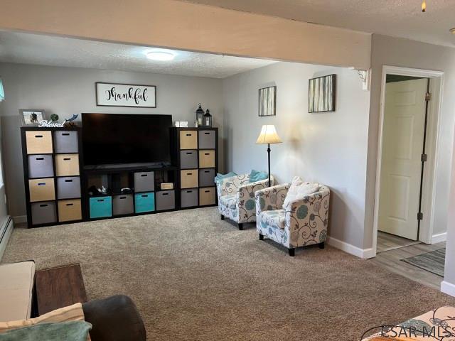 interior space with baseboards, a textured ceiling, and carpet flooring