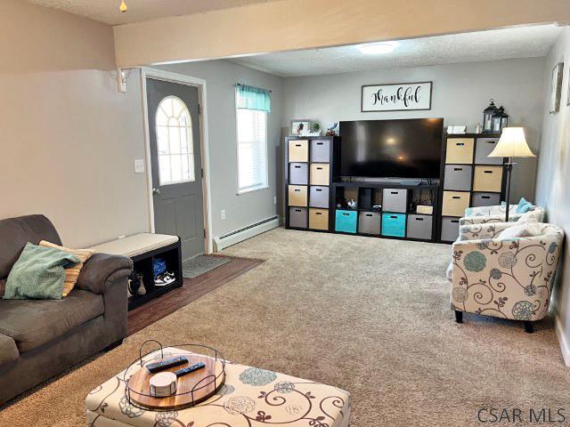 carpeted living room featuring baseboard heating