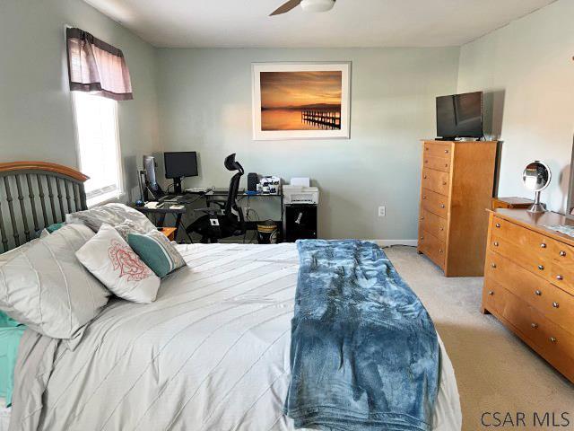 bedroom with baseboards and light carpet