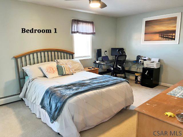 bedroom with a baseboard radiator, baseboards, and carpet floors