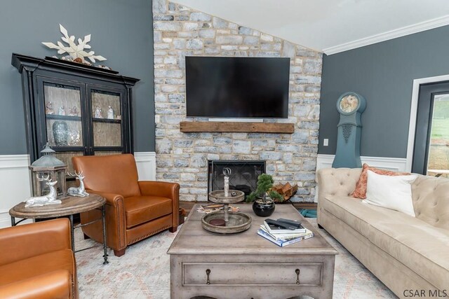 living room featuring crown molding, lofted ceiling, and a fireplace