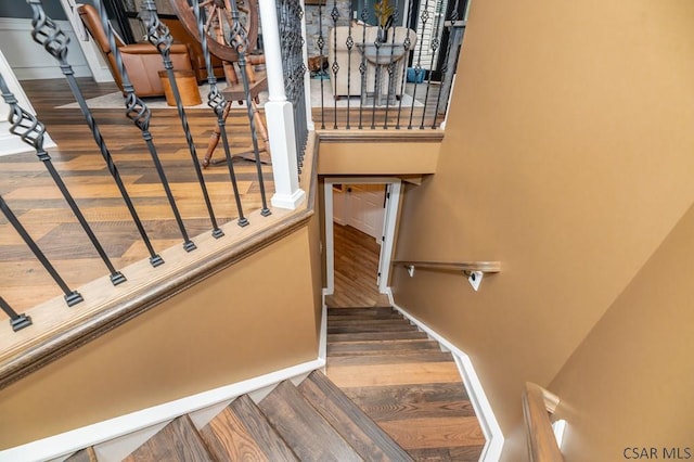 stairs with hardwood / wood-style flooring and a towering ceiling