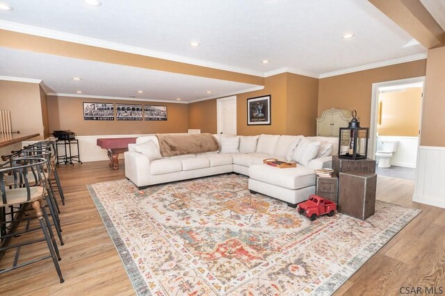 living room with ornamental molding and light hardwood / wood-style floors