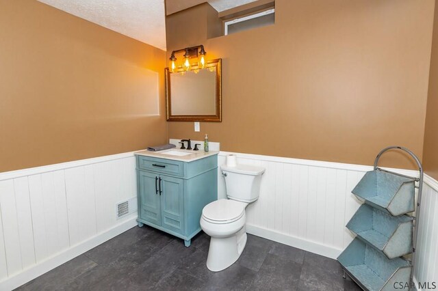 bathroom with vanity, a textured ceiling, and toilet