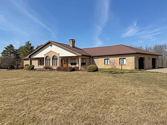 view of front facade featuring a chimney, a front lawn, and brick siding