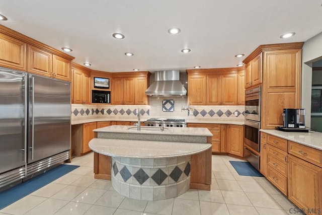 373 Hillside Ln, Somerset, PA 15501 - kitchen with stainless steel appliances, wall chimney exhaust hood, brown cabinets, a center island with sink, and a sink