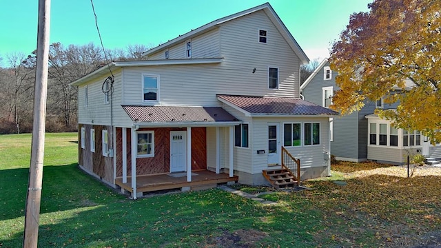 rear view of property featuring a lawn