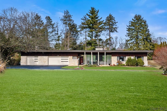 mid-century home with stone siding and a front lawn