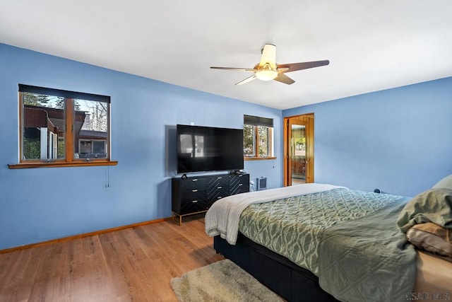 bedroom featuring baseboards, wood finished floors, and a ceiling fan