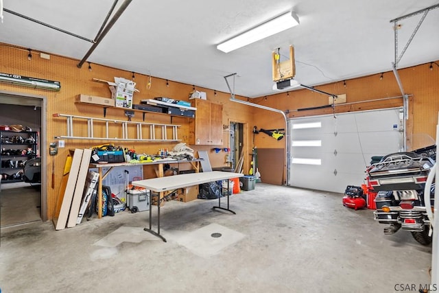 garage with a workshop area and a garage door opener