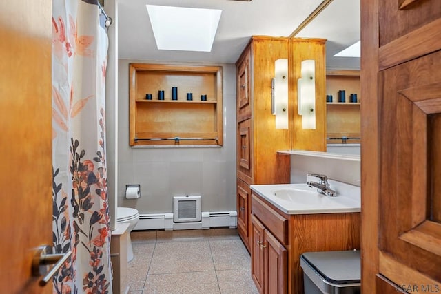 full bathroom with vanity, a baseboard radiator, a skylight, curtained shower, and toilet