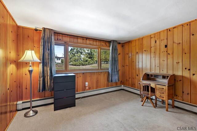 home office with wooden walls, a baseboard radiator, and light carpet