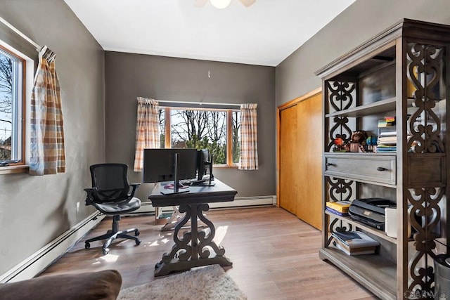 office space with a baseboard radiator, baseboard heating, and light wood-style flooring