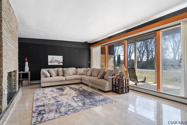 living area with a baseboard heating unit and a fireplace