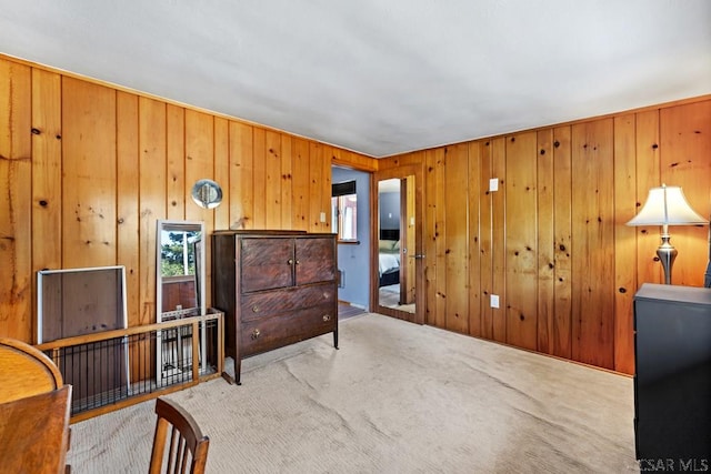 sitting room with carpet flooring and wood walls