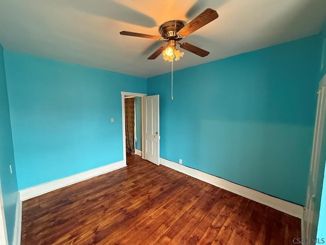 spare room featuring a ceiling fan, baseboards, and wood finished floors