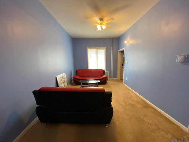 sitting room with light colored carpet, ceiling fan, and baseboards