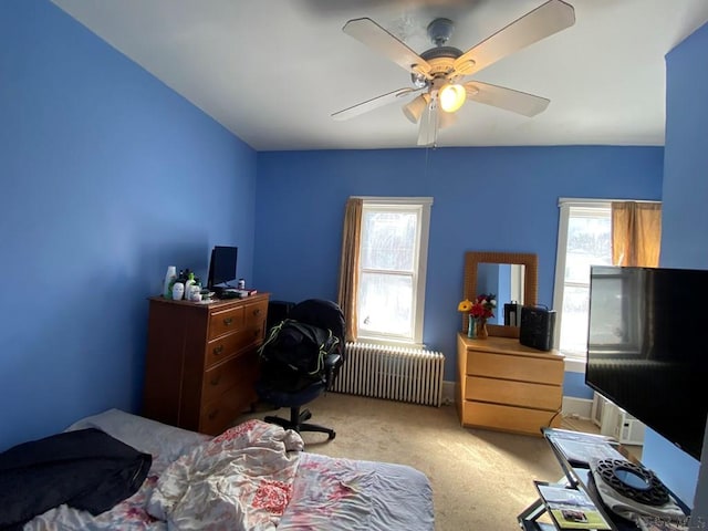 carpeted bedroom featuring ceiling fan and radiator