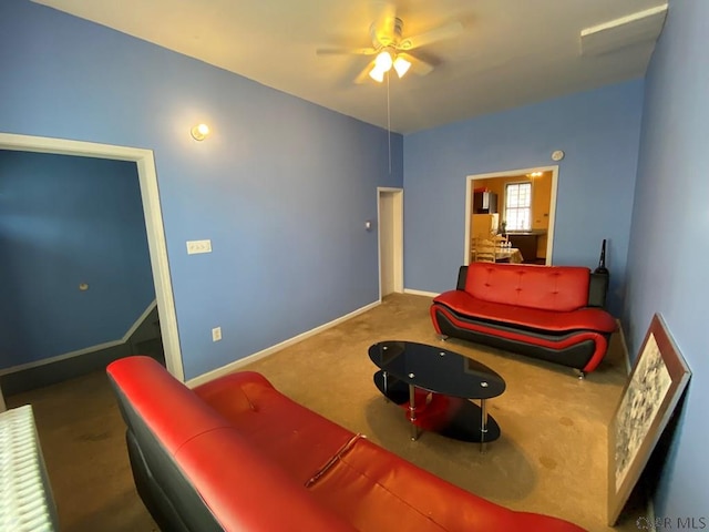 carpeted living area with baseboards and a ceiling fan